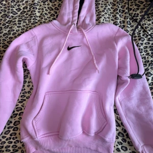 Ljusrosa Nike hoodie - Säljer en ljusrosa hoodie från Nike med svart broderat märke!🎀