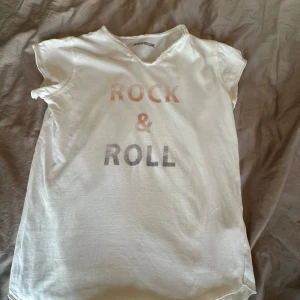 Vit t-shirt Zadig & Voltaire Rock & Roll - Vit t-shirt från Zadig & Voltaire med trycket 'ROCK & ROLL' på bröstet. Klassisk rund hals med råa kanter och korta ärmar. Skön och mjuk bomullskänsla. Använd ett par gånger men ändå i mycket bra skick! Storleken är ca 158 men passar mig som är runt 162 cm.