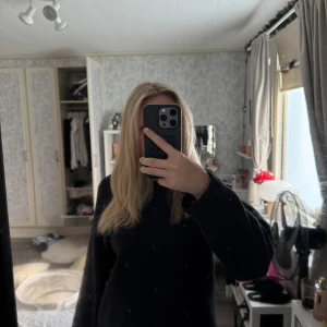 Mörkgrå stickad tröja med pärldetaljer - Mysig mörkgrå stickad tröja från H&M med små pärldetaljer över hela framsidan. Tröjan har en högre rund halsringning, långa ärmar och ribbade muddar. Perfekt för dig som gillar en enkel men ändå lite extra look.