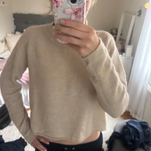 Beige stickad tröja från Zara - Supermjuk och basic beige stickad tröja från Zara med rund halsringning och långa ärmar. Perfekt till lager-på-lager och enkel att matcha med allt. Lätt loose fit och ribbade muddar vid halsen för en chill vibe.