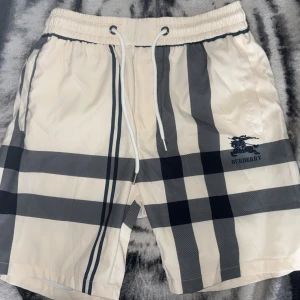 Burberry Badbyxor/Shorts - Säljer ett par burberry shorts vilket kan användas som badbyxor och vardagliga kortbyxor. Mycket snygga och helt nya med lappen kvar.       Storleken är M på byxorna men passform är mer lutande för S.                                                      Perfekt att matcha ihop med sin outfit.