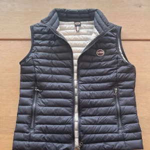 Mörkblå dunväst från Colmar - Snygg mörkblå dunväst från Colmar med quiltad design och dragkedja framtill. Köptes för 1600 men säljer för 899. Använt typ 2 gånger 