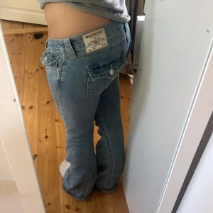 True Religion bootcut jeans - Ljusblå jeans från True Religion med bootcut passform och låg midja. Modellen Joey storlek 27