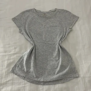 Ljusgrå t-skirt från hm - T-shirten har rund halsringning och korta ärmar. Endast använd 1 gång så i mycket bra skick!