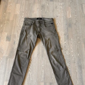 Anbass jeans från Replay - Snygga grå jeans från Replay med klassisk femficksdesign och detaljerad bakficka med broderi. Jeansen har raka ben och normal passform, tillverkade i mjukt jeanstyg. 