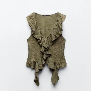 Zara topp - Supersnygg olivgrön topp från Zara med omlottmodell och volangkant längs v-ringningen och nederdelen. Storlek M men passar mig som vanligtvis har S❤️