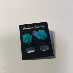 Handformade Turkosa rosformade örhängen *Endast 1 Kvar* - Snygga örhängen i form av turkosa rosor från Fashion Jewelry. De har en cool 3D-effekt och är perfekta för att ge din look en färgklick. Passar dig som gillar blommiga detaljer och vill sticka ut lite extra.