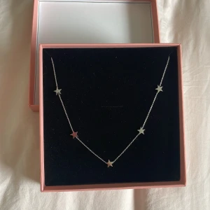 Edblad SILVERFÄRGAT HALSBAND MED STJÄRNOR SMYCKA - Supersnyggt halsband frånedblad, inköpt på  Smycka i silverfärg med flera små stjärnformade hängen längs en tunn kedja. Perfekt för dig som gillar minimalistiska smycken med en twist. Kommer i originalask och har justerbar längd.