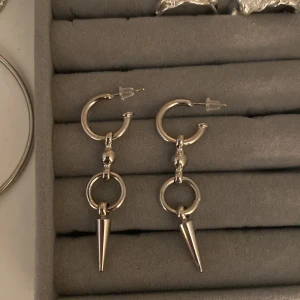Silvriga örhängen med spikes - Ett par örhängen i silver . Andvända 3-4 gånger bara så är i ett väldigt nytt skick. Original pris är ca 200 kr🩷(priset går att diskutera)