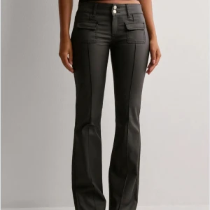 Svarta bootcut byxor med fickdetaljer - Snygga svarta bootcut byxor med lågm midja och stilrena fickdetaljer framtill.  Byxorna har använts 2/3 gånger bara så det är mycket bra skick. Storleken är 38 