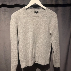 Kashmir Tröja Uniqlo - Säljer en stilren grå tröja från Uniqlo. Tröjan är långärmad och har en klassisk rund halsringning. Bra skick, hör av dig vid minsta fundering!