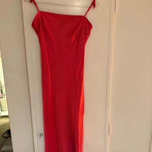 Rosa balklänning  - Snygg rosa klänning i ett glansigt material. Perfekt för en kväll ute eller en speciell tillställning. Klänningen har en elegant och enkel design som framhäver figuren.