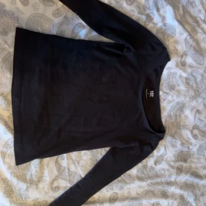 svart långärmad topp från lager157 - säljer en stilren svart långärmad topp från lager 157 i storlek s! den är väldigt stretchig så passar även större storlekar. tröjan har en rund halsringning och är tillverkad i 95% bomull. 