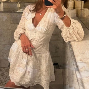 Vit klänning med spetsdetaljer - Säljer en söt vit klänning med spetsdetaljer och v-ringning. Klänningen har långa ärmar och en volangkant nedtill. Perfekt för sommarens alla tillfällen. 💫Superfin studentklänning eller till midsommar!! Den har en fläck på ena armen sen tidigare ägare men går säkert bort i tvätten!