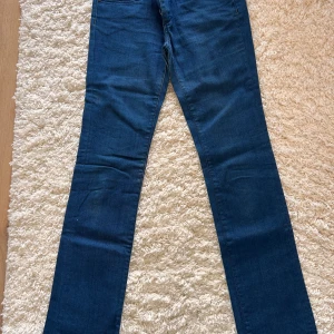 Blå jeansbyxor från Only - Snygga blå jeansbyxor från Only med klassisk femficksdesign. De har en normal passform och är tillverkade i en stretchig bomullsblandning. Perfekta för en avslappnad stil.