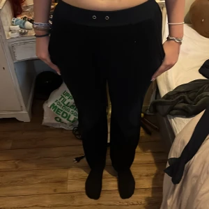 Svarta byxor från Juicy Couture - Snygga svarta byxor från Juicy Couture med en bekväm passform. Byxorna har en elastisk midja och dekorativa fickor bak. Perfekta för en avslappnad stil.