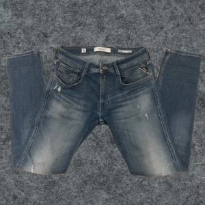 Blå jeans från Replay - Säljer ett par snygga blå jeans från Replay, modell Anbass. Storlek: W31 o L32. De har en klassisk femficksdesign med lätt slitna detaljer för en cool look. Perfekta för en avslappnad stil.