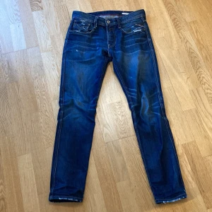 Blå jeans från Replay - Säljer ett par Replay Anbass jeans med sköna slitningar. De är i storlek 32/32. Skicket är ca 8/10, slitningarna är endast estetiska. Skriv vid funderingar📈🤩