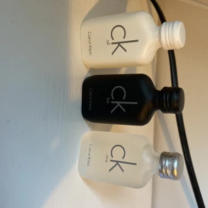 Set med tre parfymer från Calvin Klein -  Alla är oöppnade och är fulla Säljer ett set med tre miniflaskor av Calvin Klein-parfymer: CK All i vit flaska, CK Be i svart flaska och CK One i frostad flaska. Perfekt för att prova olika dofter. 