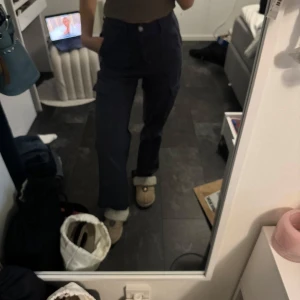 Mörkgråa cargopants - Säljer ett par mörkblå cargopants med flera fickor och en avslappnad passform. 