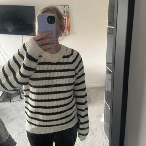 Randig stickad tröja från Lindex - Säljer en mysig stickad tröja från Lindex i svart och vitt. Tröjan har ett klassiskt randigt mönster och långa ärmar. Perfekt för kyligare dagar. Den är väldigt stor i storleken så passar även xs/s💞