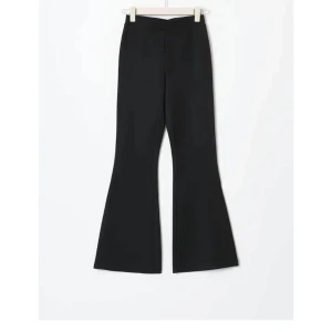 Svarta byxor från Gina Tricot - Snygga svarta byxor från Gina Tricot med en trendig bootcut-stil. Byxorna är högmidjade och tillverkade i en mjuk blandning av viskos och polyester, vilket ger en bekväm passform. Perfekta för att skapa en stilren look.