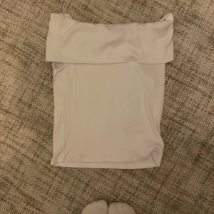 Vit no shoulder tröja - Säljer en stilren vit bo shoulder som är perfekt för sommardagar. Tröjan har en enkel design och är gjord i ett mjukt material som ger en bekväm passform. Perfekt att matcha med en färgglad kjol eller ett par snygga jeans.