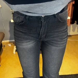 Svarta jeans med hög midja - Snygga gråa jeans med hög midja och dragkedja. De har en tight passform och klassisk femficksdesign. Perfekta för en stilren look. STORLEK M