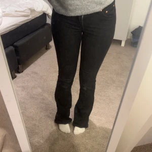 Svarta jeans - Snygga svarta jeansbyxor med en tight passform och hög midja. De har en klassisk femficksdesign och stängs med dragkedja och knapp. 