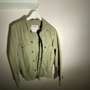 Grön jacka från Pull&Bear - Grön overshirt från Pull & Bear – stl S  Säljer en snygg och stilren overshirt från Pull & Bear i storlek S. Perfekt som ett lätt ytterplagg eller som en del av en lager-på-lager-look. Stilren design i en mörkgrön nyans, passar både till vardags och uppklätt.  ✔ Märke: Pull & Bear ✔ Storlek: S ✔ Färg: Grön ✔ Skick: Mycket bra – inga tecken på användning  Finns för avhämtning eller kan skickas! Skicka PM vid intresse