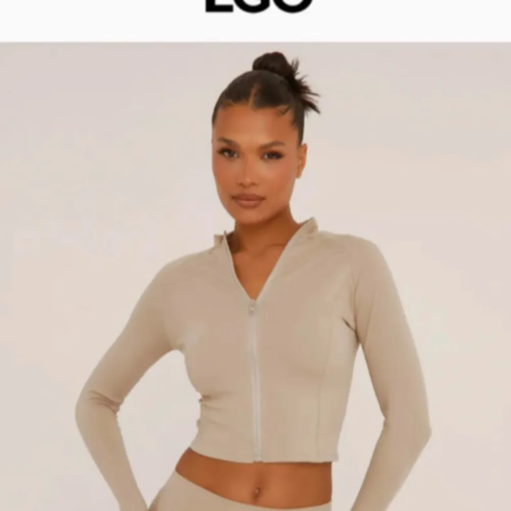 Snygg beige träningsjacka från Ego med dragkedja framtill. Jackan har en tight passform och långa ärmar, perfekt för träning eller en aktiv vardag. Nyskick! Storlek 36 (liten i storleken!). . Takit.