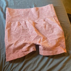 Rosa shorts - Säljer ett par rosa shorts i en mjuk och stretchig blandning av polyamid, polyester och elastan. De har en hög midja och en bekväm passform, perfekta för träning eller avslappnade dagar.