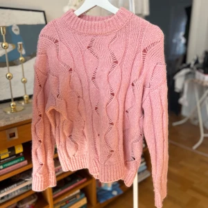 Rosa stickad tröja från Soaked - Säljer en söt rosa stickad tröja från Soaked. Tröjan har ett vågigt mönster och är långärmad med ribbade kanter vid hals och ärmslut. Perfekt för kyliga dagar!