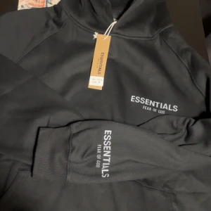 Mysig Essentials hoodie! - Snygg svart hoodie från Essentials storlek M, men sitter fint på Small för en större baggy look eller large med mysig hoodieeee!!!