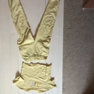 Gult sett med tryck "ALIVE" - Gult sett från Bo Ohlsson. Tryck på tröjan "ALIVE". Tröjan var från början långärmad och lite längre men är nu klippt som en kort t-shirt. Lurvigt foder inuti. Perfekt för en vår och sommar look! 30kr för båda!