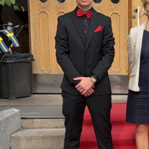 Svart dressman kavaj med röda detaljer - Elegant svart kostym med matchande byxor och kavaj. Inkluderar en röd fluga och näsduk för en stilfull touch. kostymen 44 regular finns även kostym byxor till salu