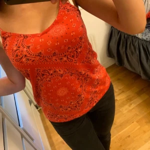 Röd mönstrad linnetopp från Primark - Säljer en röd linnetopp från Primark med paisley-inspirerat mönster. Toppen har tunna axelband och är perfekt för varma dagar. Lätt och bekväm att bära, passar snyggt till både jeans och kjol. Storlek 36z