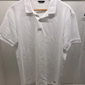 Vit pikétröja från Massimo Dutti - Klassisk vit pikétröja från Massimo Dutti med krage och korta ärmar. Aldrig använt den så säljer den pga det.