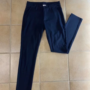 Mörkblå kostymbyxor från Grunt - Snygga mörkblå kostymbyxor från Grunt. Storlek 27 men är ganska stora i storleken så passar nog 28. Skick 8/10. Nypris runt 500, mitt pris 100.