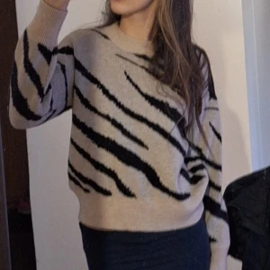 Beige stickad tröja med zebramönster - Säljer en beige stickad tröja med svart zebramönster. Tröjan har rund halsringning och långa ärmar. Är i storlek M och har aldrig använt🩷