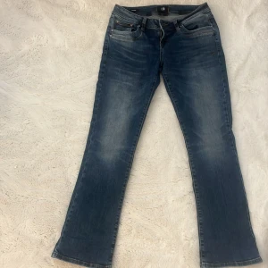 Blå bootcut jeans från LTB - Säljer ett par klassiska blå bootcut jeans från LTB. Jeansen har fem fickor, normal passform och lätt slitning framtill. 36/8/S