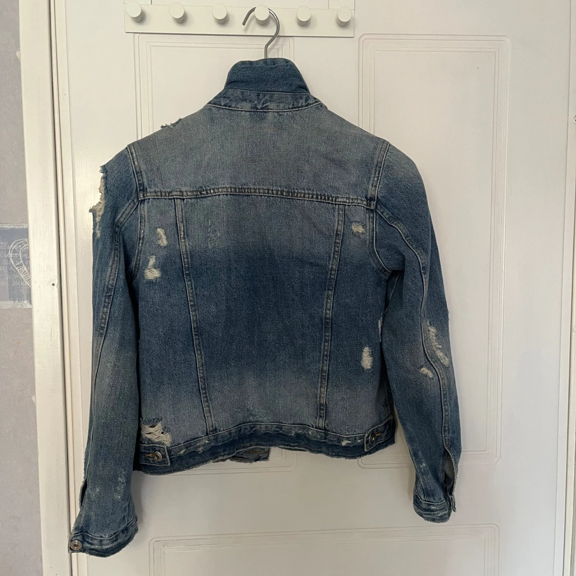 Blå jeansjacka med slitningar - 1