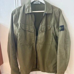 Stone Island overshirt - Säljer en snygg grön overshirt/jacka från Stone Island. Inga defekter alltså väldigt fint skick! Storlek S men passar även M. Skriv om du har frågor!