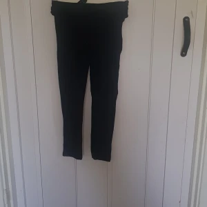 Svarta leggings med bakficka - Svarta leggings i stretchigt material med en bakficka. Perfekta för dig som vill ha en enkel och bekväm stil. Resår i midjan för extra komfort. Passar till det mesta och är lätta att matcha med andra plagg.