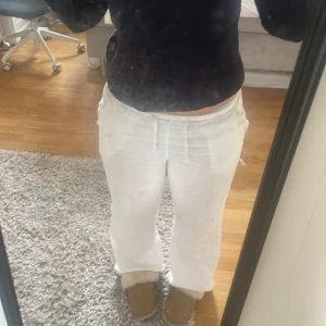 Vita linnebyxor med snörning - Säljer ett par vita linnebyxor med avslappnad passform och dragsko i midjan. Byxorna har raka ben och är perfekta för en chill och luftig stil. Materialet är lätt och svalt, perfekt för varmare dagar.