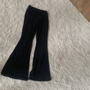 Svarta bootcut byxor från SHEIN - Svarta bootcut byxor från SHEIN i stretchigt material. Byxorna har en hög midja och vida ben som ger en snygg siluett. Perfekta för dig som gillar en trendig och bekväm look.
