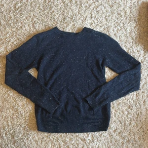 Mörkblå stickad tröja med vita prickar - Mysig mörkblå stickad tröja med vita prickar i garnet. Klassisk rund halsringning och långa ärmar. Perfekt för lager-på-lager och chill dagar. Passar dig som gillar enkel men snygg stil.