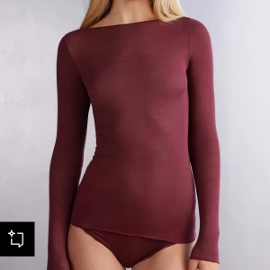 Vinröd intimissimi tröja - Vinröd långärmad topp med rund halsringning och tight passform. Tillverkad i tunn och mjuk merinoull som känns skön mot huden. De finns ett litet hål på ena ärmen (se sista bilden) men inget som syns när man har på sig den!