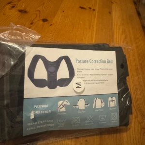 Svart hållningskorrigerande bälte M - Säljer ett svart hållningskorrigerande bälte i storlek M. Bältet är justerbart och tillverkat i ett lätt, mjukt och andningsbart material. Perfekt för dig som vill förbättra din hållning och få extra stöd för ryggen. Enkel att ta på och använda.