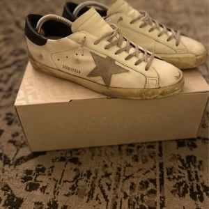 Golden goose Super-Star with suede star and blue heel tab - WTS!!!  Säljer nu mina Golden goose Super-Star with suede star and blue heel tab. Den perfekta sommarskon som fungerar hur bra som helst året runt. Säljer pga knappt kommit till användning.   Cond: 9/10 - använt fåtal gånger  Size: 44 eu Allt og medföljer - Box, Kvitto etc. Bin: 3500  Nypris: $575  Frakten står köparen för!   Finns det några frågor eller funderingar så tveka inte på att höra av er.   Allt gott,   Martin